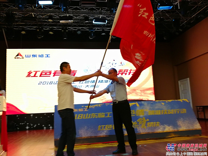 山东临工工程机械有限公司副总经理史生勇为山东临工“红色情”精准扶贫大凉山分队授旗
