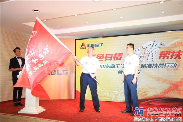 唐俊斌副总经理将扶贫旗帜交于延安站扶贫小分队队长、陕西鼎新董事长翟文斌手中