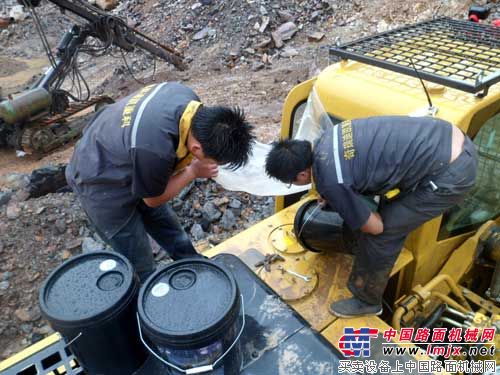 加注液壓油時，服務人員細心地用塑料膜擋住注油口，防止雨水落入