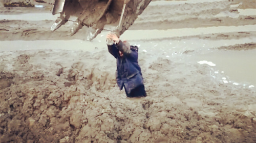 实拍男子陷泥泞中挖掘机救援现场