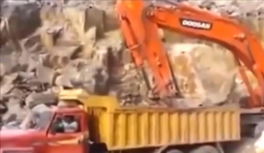 挖掘機這樣給卡車丟大石頭裝料，嚇得貨車司機馬上跳下車！